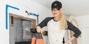 Galey Alix din casa lui Hgtv într-o clipă stând pe scară purtând tricou împrăștiat cu vopsea șapcă de blugi