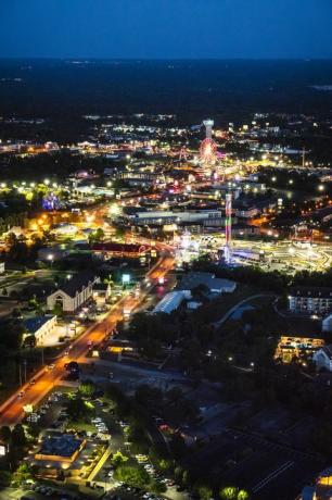 vedere aeriană pe timp de noapte a autostrăzii 76, Branson Missouri, cu roată feris iluminată cu neon, turn și multe altele