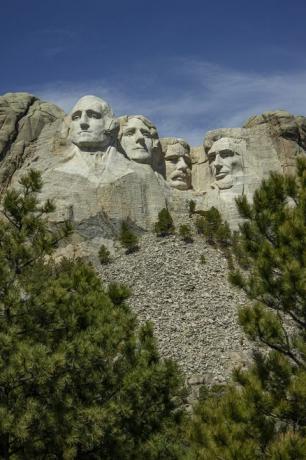 Monumentul național Mount Rushmore cu capete de piatră ale lui Jefferson, Lincoln, Teddy Roosevelt și Washington cu cerul albastru în fundal