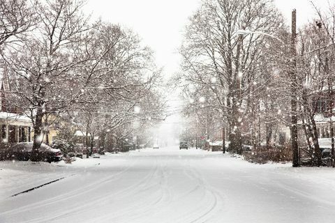 Zăpada căzând pe strada suburbană