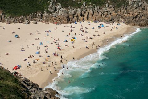 Oamenii se bucură de vremea bună pe plaja Porthcurno, lângă Penzance 