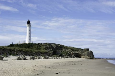 Scena de coastă cu far și peșteri de mare