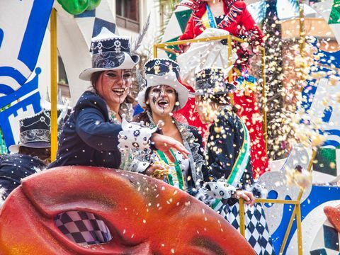 Algeciras, participanții la carnaval care râd veseli aruncă confetti în timpul paradei carnavalului pe stradă din Algeciras, Cadiz, Andaluzia