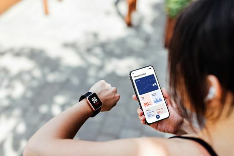 tânără care folosește aplicația de urmărire a fitness-ului pe ceasul inteligent și pe smartphone