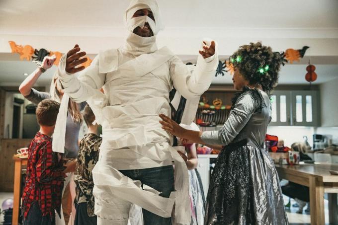 bărbat în costum de mumie din hârtie igienică la petrecerea de Halloween cu un joc amuzant de mumie pentru o legendă