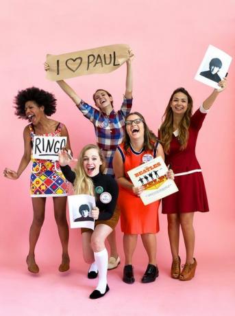 cinci femei îmbrăcate în beatlemaniacs în haine vintage râzând și urlând, una ține albumul beatles