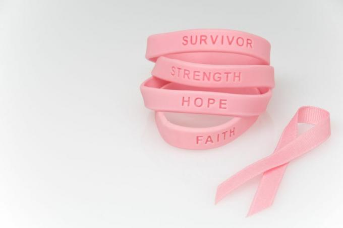 teanc de brățări de cauciuc roz citind supraviețuitor, putere, speranță, credință și panglică roz lângă el